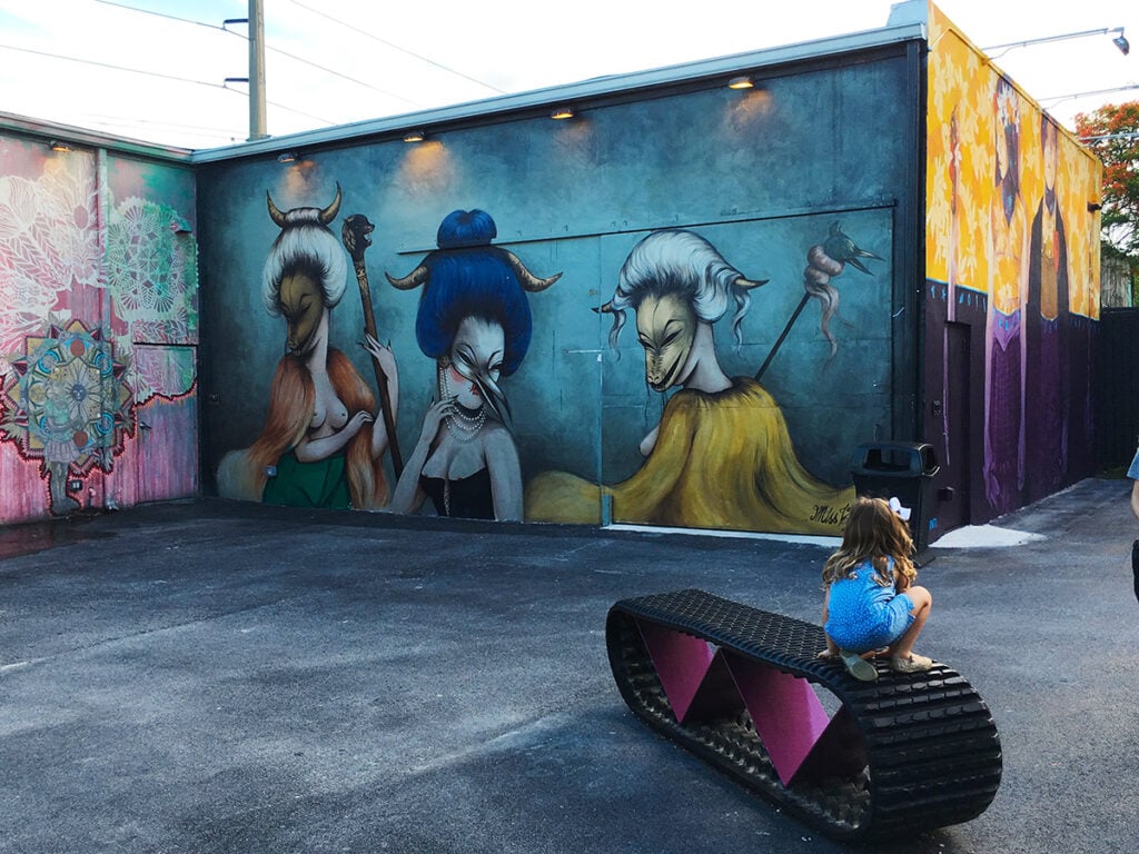 Child playing in front of mural wall at Wynwood